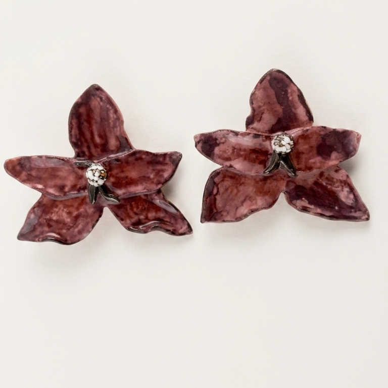 Pair of lila butterfly-shaped earrings on a white background