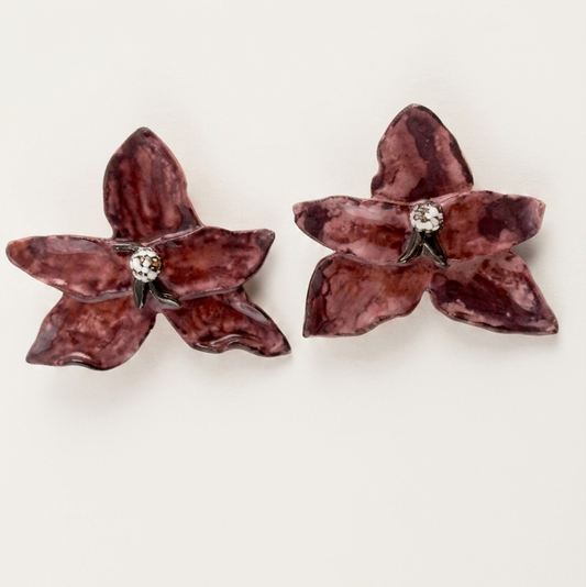 Pair of lila butterfly-shaped earrings on a white background